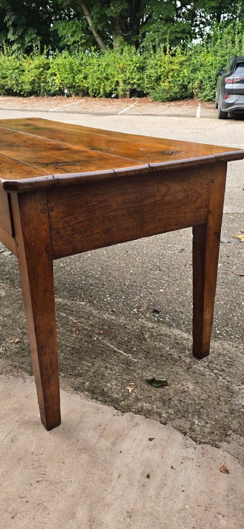 A rectangular French cherry wood refectory dining table featuring a three-plank top, side frieze drawer with metal handle, and square tapered legs. View VII