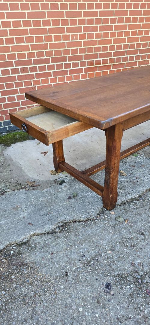 A long solid French oak refectory dining table featuring a plank top and straight legs connected by a low stretcher. View IV