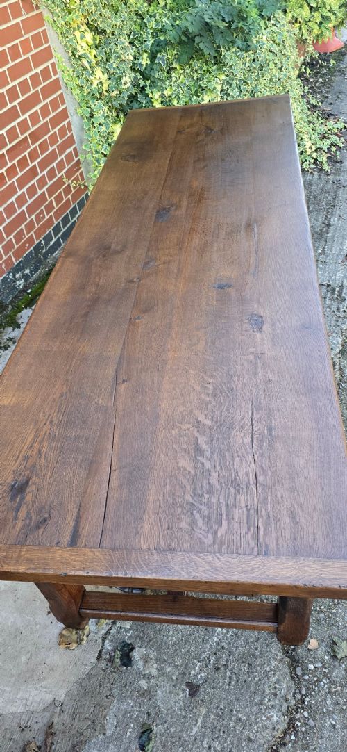 A long solid French oak refectory dining table featuring a plank top and straight legs connected by a low stretcher. View X