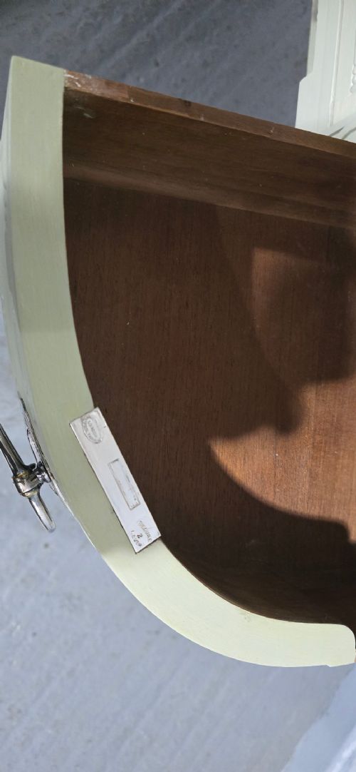 A sage green painted dressing table featuring an integrated central shield mirror, side trinket drawers, metal scroll sconces, and tapered legs. View VIII