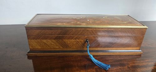 fig 1. A rectangular antique French wooden glove box with floral marquetry inlay on the lid and a blue tassel attached to the key.