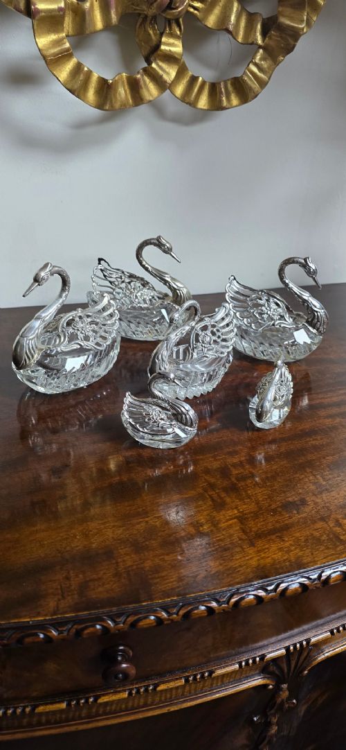 A group of cut glass open salt cellars shaped like swans with silver heads and detailed pierced silver wings. View IV