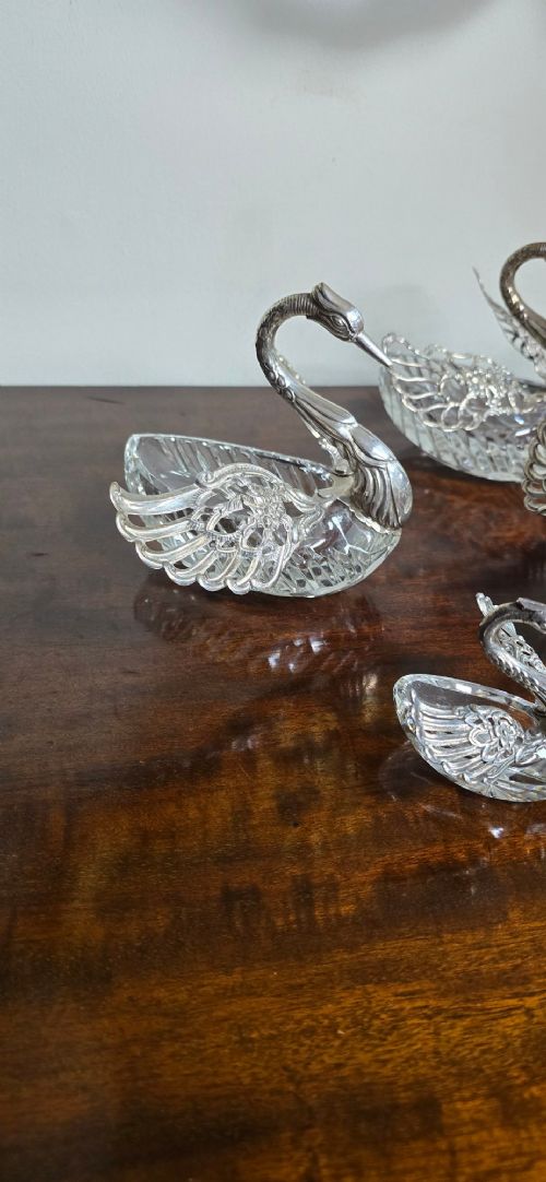 A group of cut glass open salt cellars shaped like swans with silver heads and detailed pierced silver wings. View IX