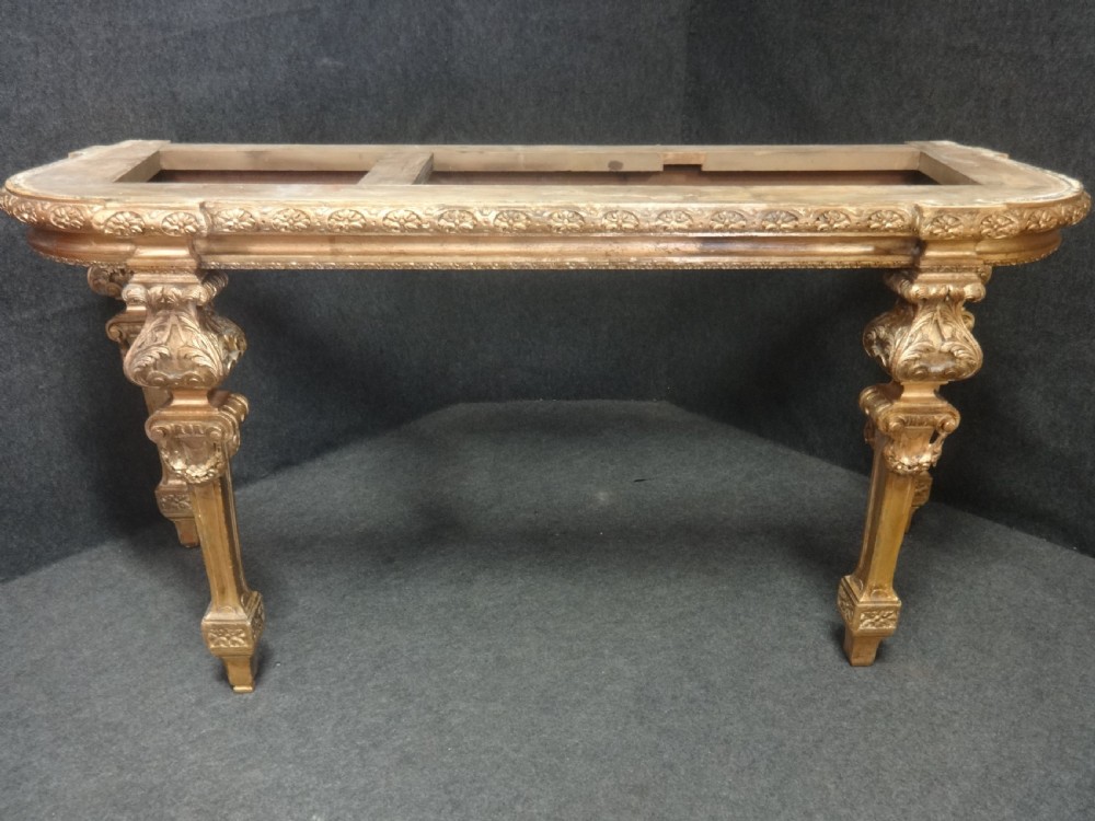 A Regency period giltwood console table featuring carved scroll support legs and a white marble top. View II