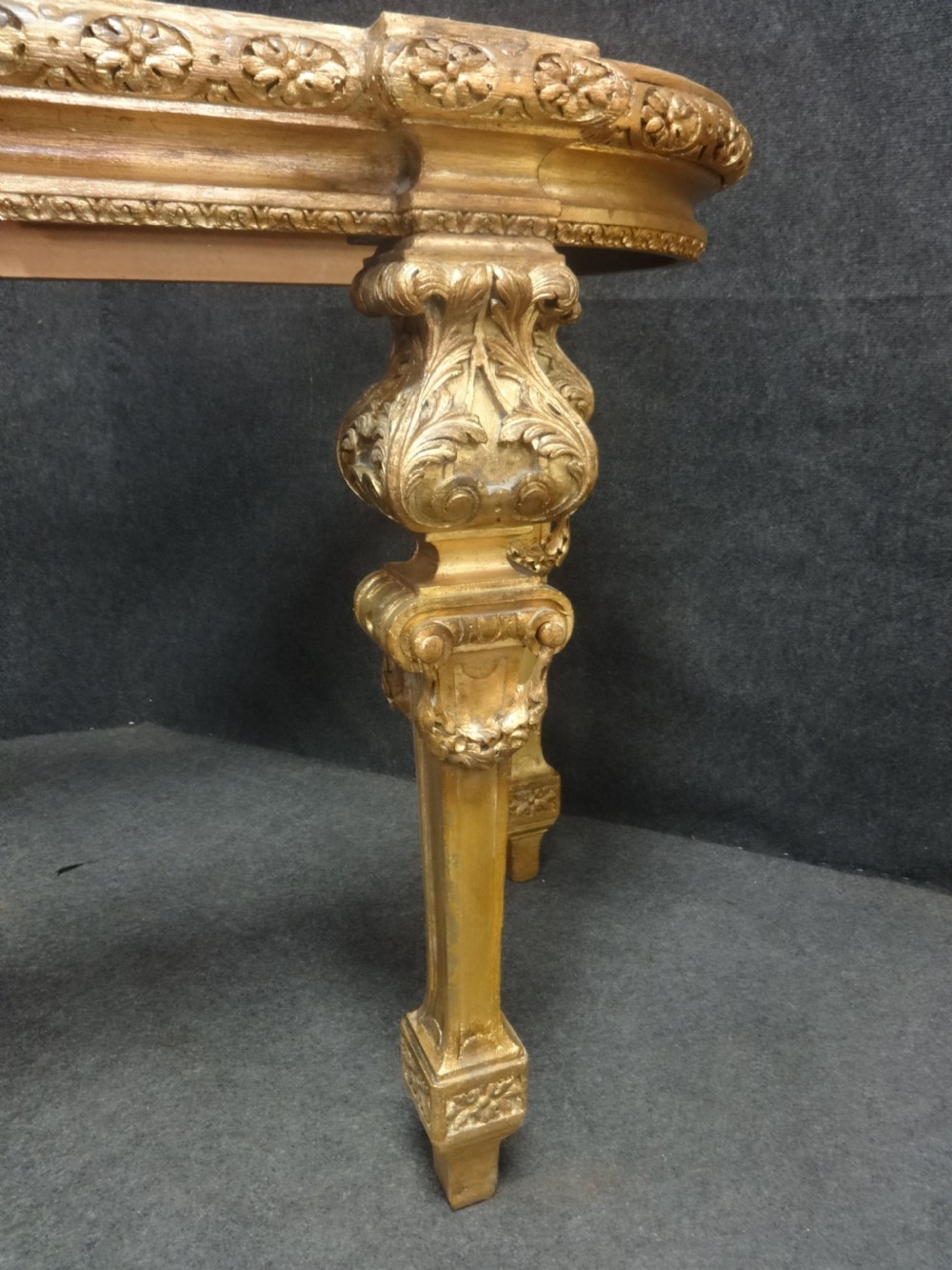 A Regency period giltwood console table featuring carved scroll support legs and a white marble top. View III