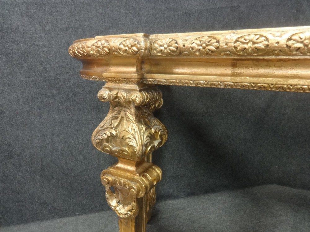 A Regency period giltwood console table featuring carved scroll support legs and a white marble top. View V