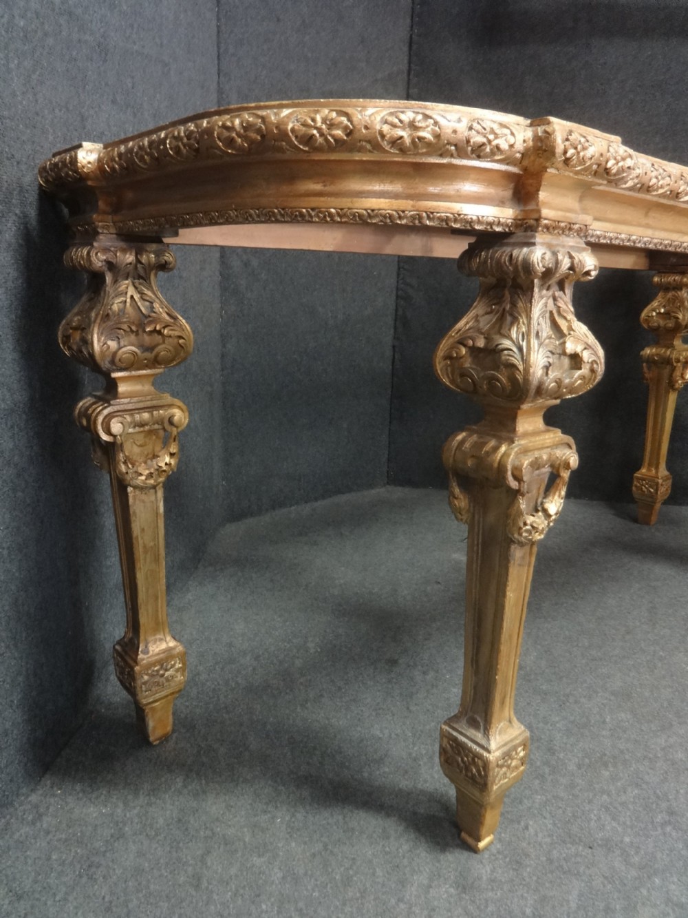 A Regency period giltwood console table featuring carved scroll support legs and a white marble top. View VI