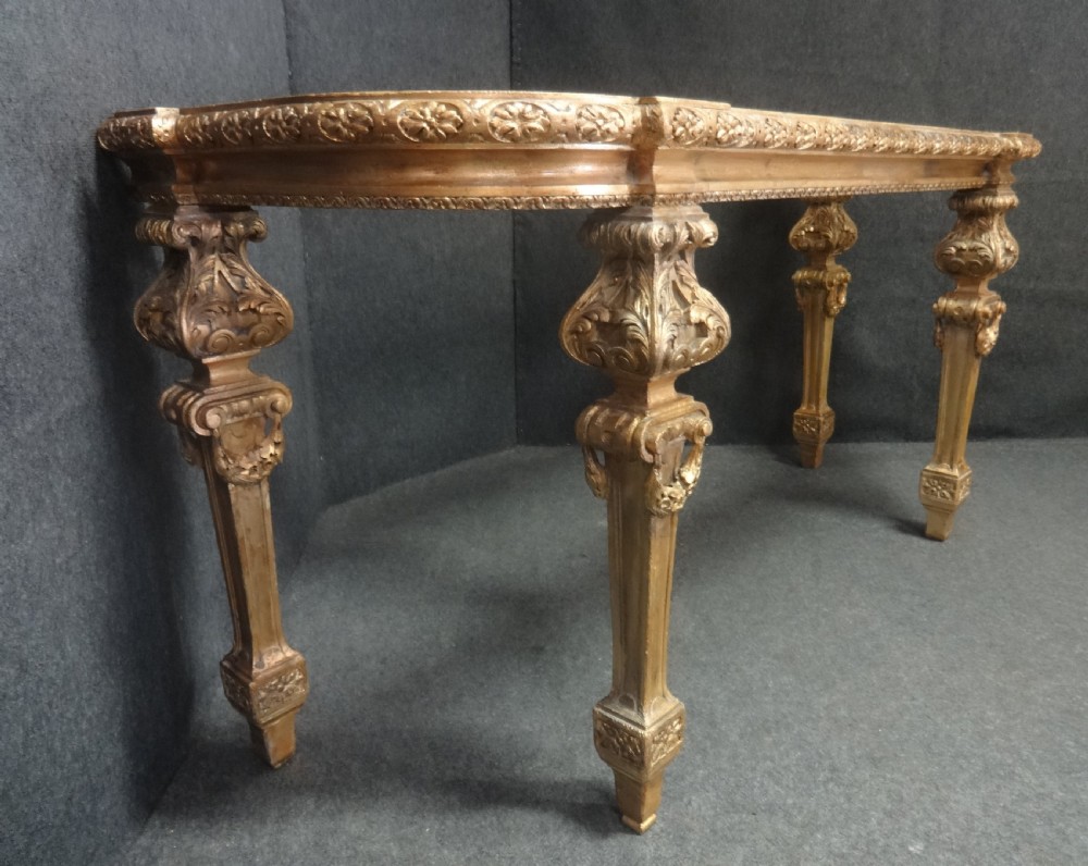 A Regency period giltwood console table featuring carved scroll support legs and a white marble top. View VII