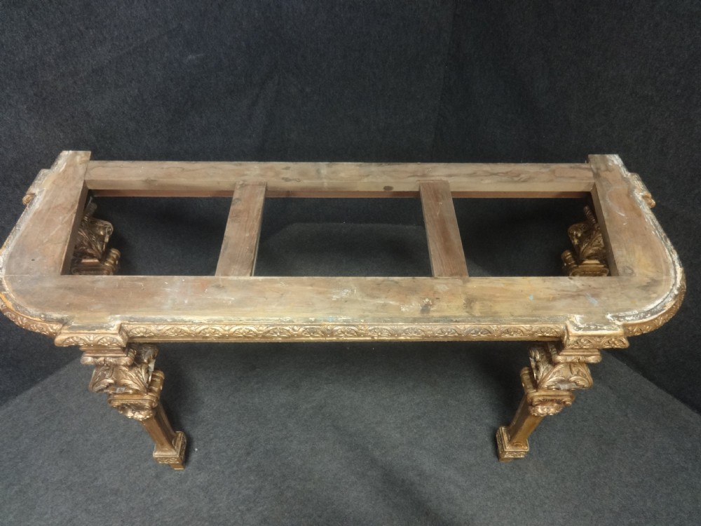 A Regency period giltwood console table featuring carved scroll support legs and a white marble top. View IX