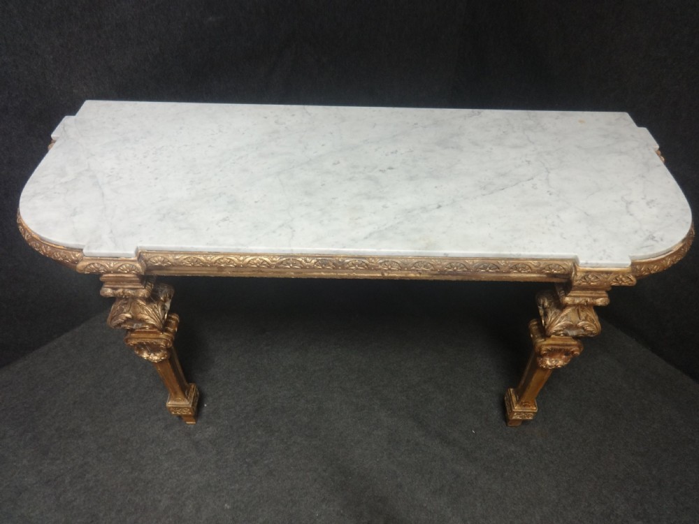 A Regency period giltwood console table featuring carved scroll support legs and a white marble top. View XI