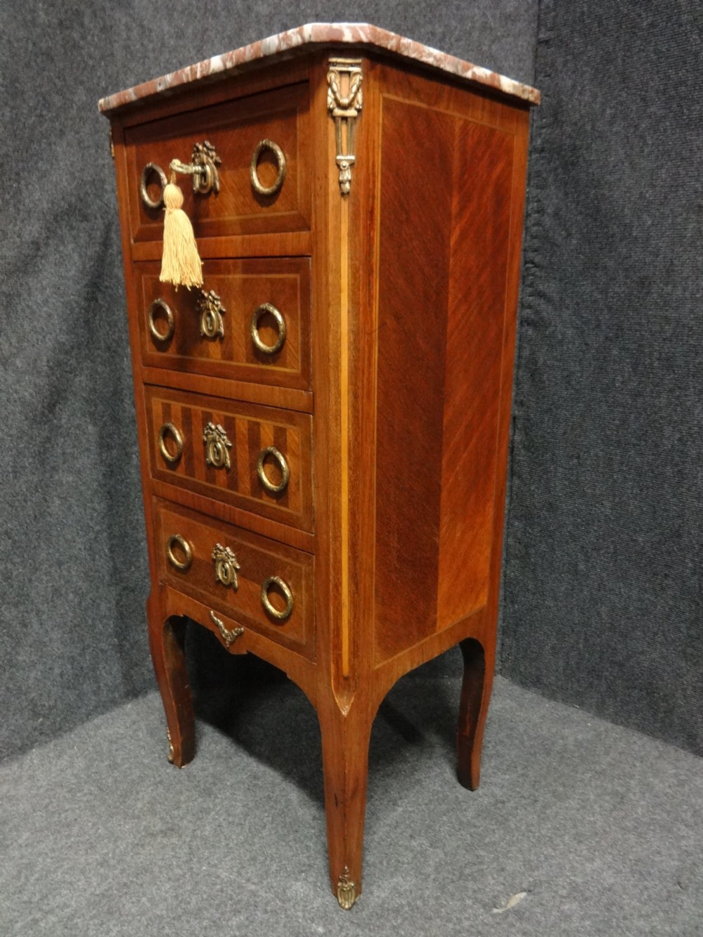 A tall French tulipwood chest featuring four drawers with geometric parquetry inlay, brass ring handles, cabriole legs, and a fitted marble top. View III