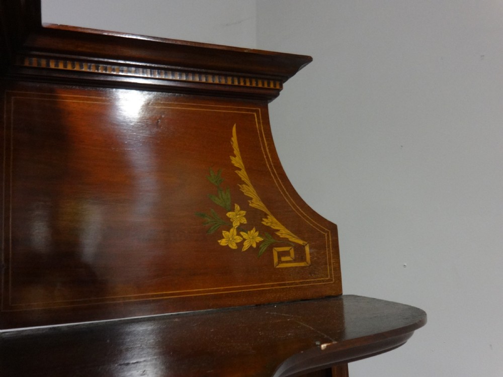 An Edwardian mahogany display cabinet featuring a broken swan-neck pediment, a central glazed door, oval mirrors, and satinwood inlay. View VIII