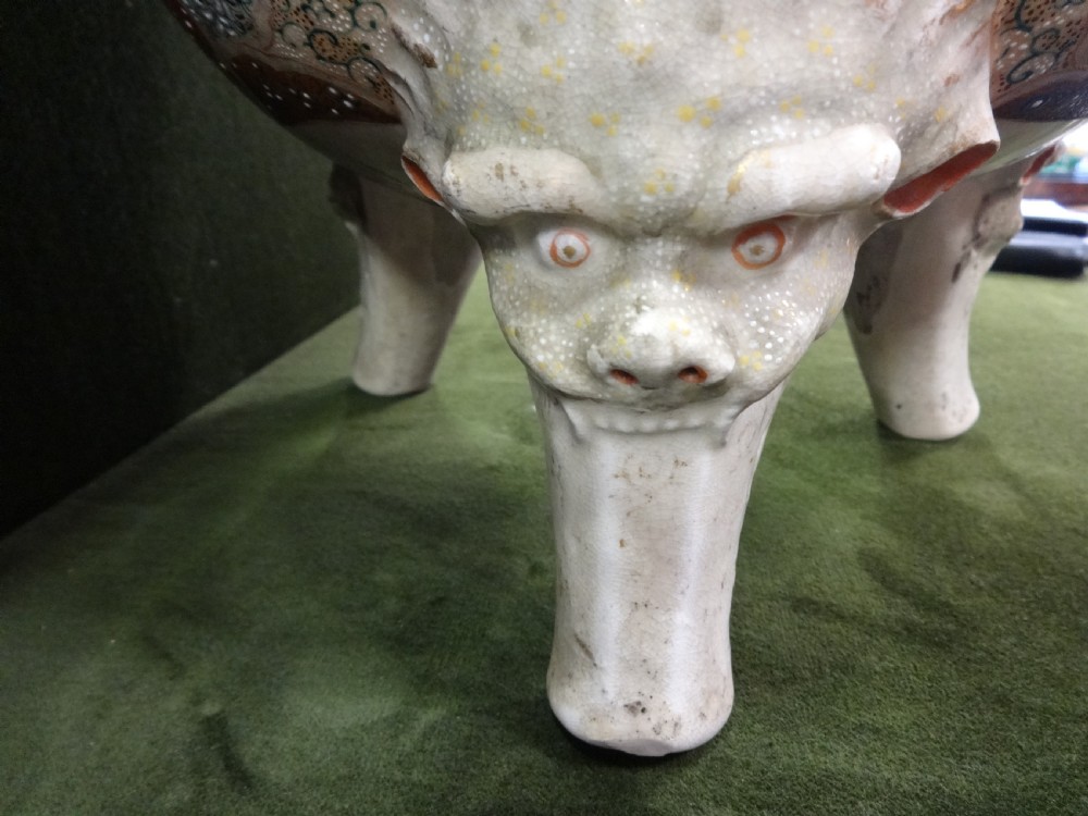 An antique Japanese Satsuma ceramic koro incense burner featuring tripodic legs, side handles, hand-painted figures, gold embellishments, and a seated figure finial on the lid. View XI