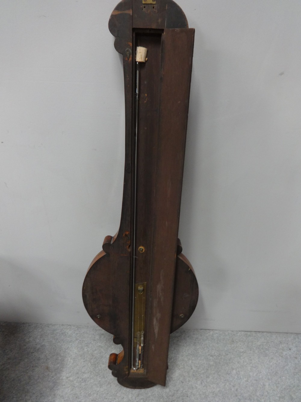 A nineteenth-century rosewood wheel mercury barometer with a brass-trimmed silvered dial and an integrated thermometer tube. View V