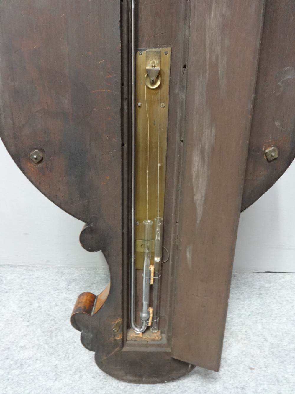 A nineteenth-century rosewood wheel mercury barometer with a brass-trimmed silvered dial and an integrated thermometer tube. View VI