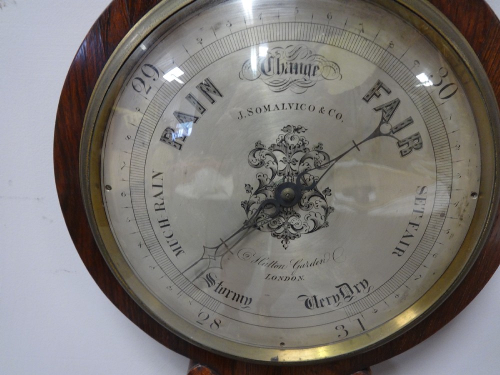 A nineteenth-century rosewood wheel mercury barometer with a brass-trimmed silvered dial and an integrated thermometer tube. View VII