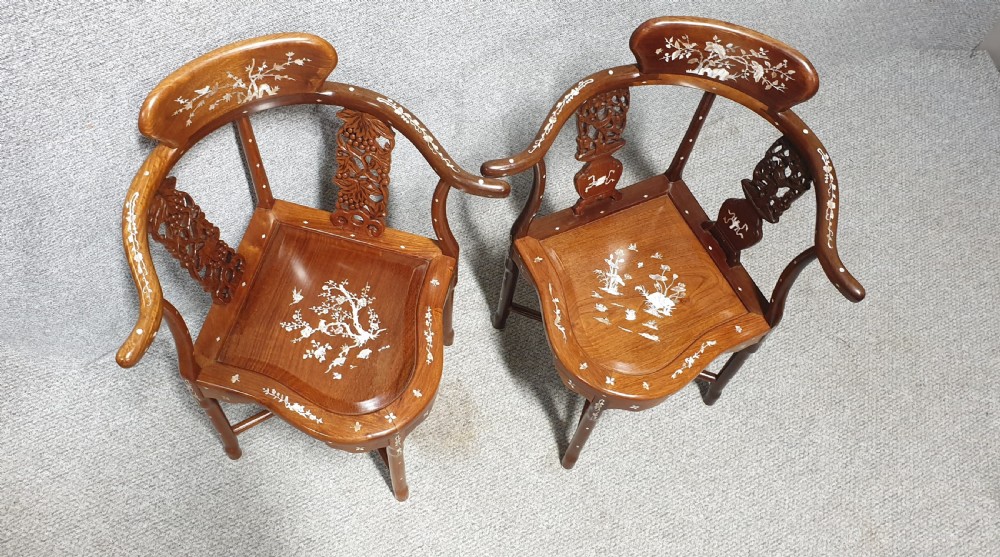 A pair of warm brown hardwood Chinese corner chairs featuring intricate mother-of-pearl floral inlays and carved pierced back splats. View V