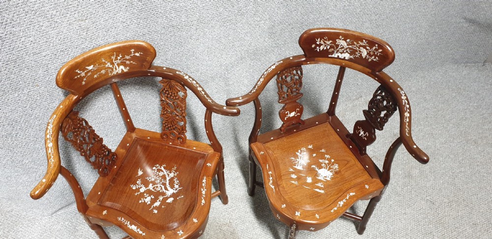 A pair of warm brown hardwood Chinese corner chairs featuring intricate mother-of-pearl floral inlays and carved pierced back splats. View VI