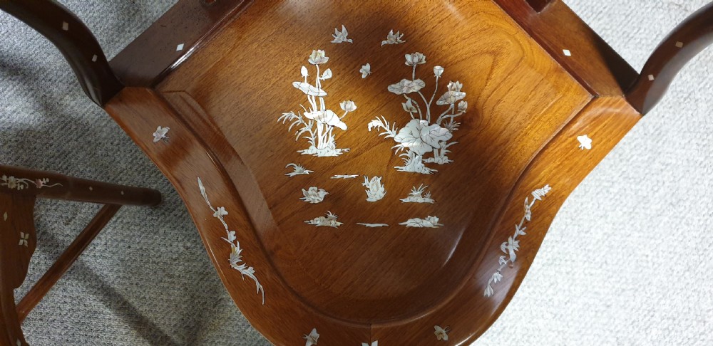 A pair of warm brown hardwood Chinese corner chairs featuring intricate mother-of-pearl floral inlays and carved pierced back splats. View IX