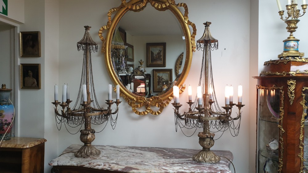 A pair of tall giltwood and metal eight-branch French candelabra table lamps featuring hanging wire swags and a tented canopy top. View XIV