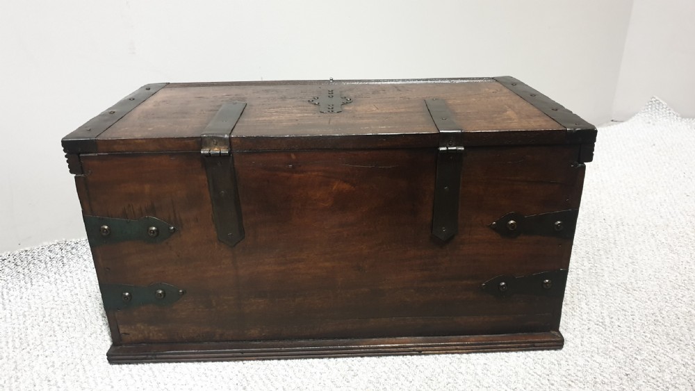 A dark mahogany wooden chest featuring decorative forged iron strapwork, corner brackets, and a central iron escutcheon plate. View VII