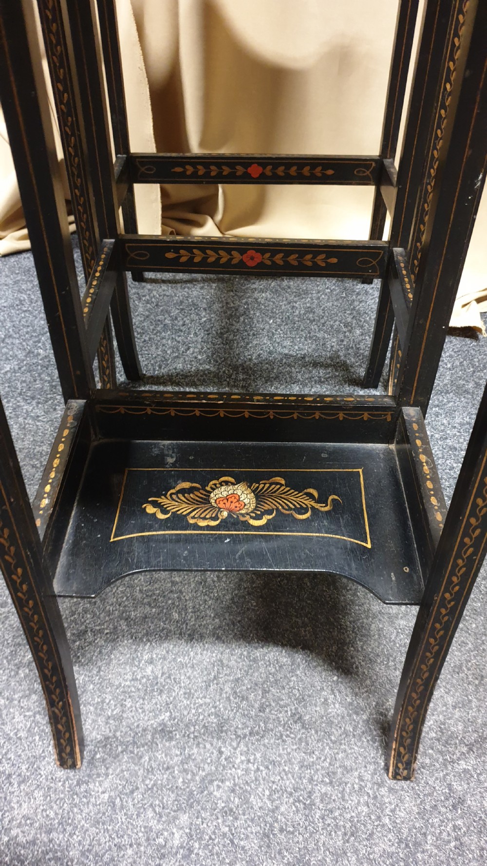 A set of three black lacquered Chinoiserie nesting tables decorated with gilded landscapes and shell inlay. View IV