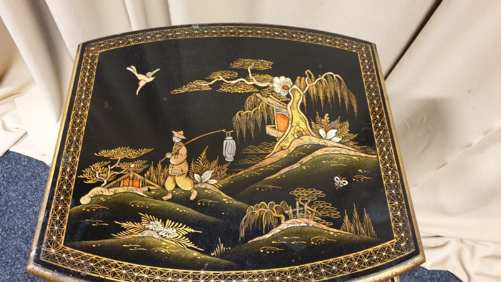 A set of three black lacquered Chinoiserie nesting tables decorated with gilded landscapes and shell inlay. View VI