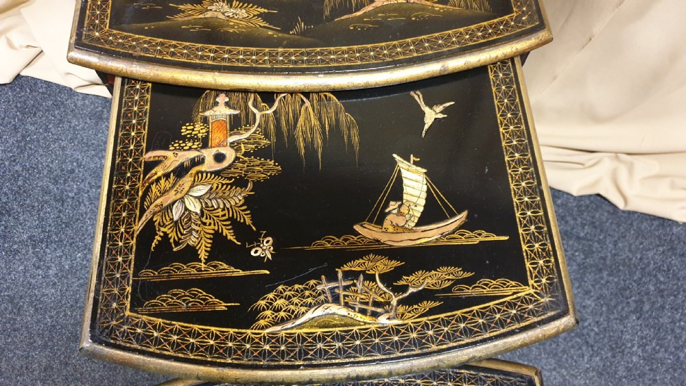 A set of three black lacquered Chinoiserie nesting tables decorated with gilded landscapes and shell inlay. View VII