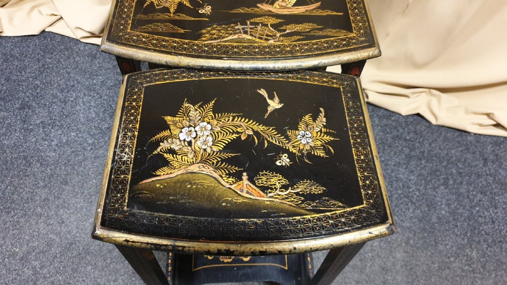 A set of three black lacquered Chinoiserie nesting tables decorated with gilded landscapes and shell inlay. View VIII