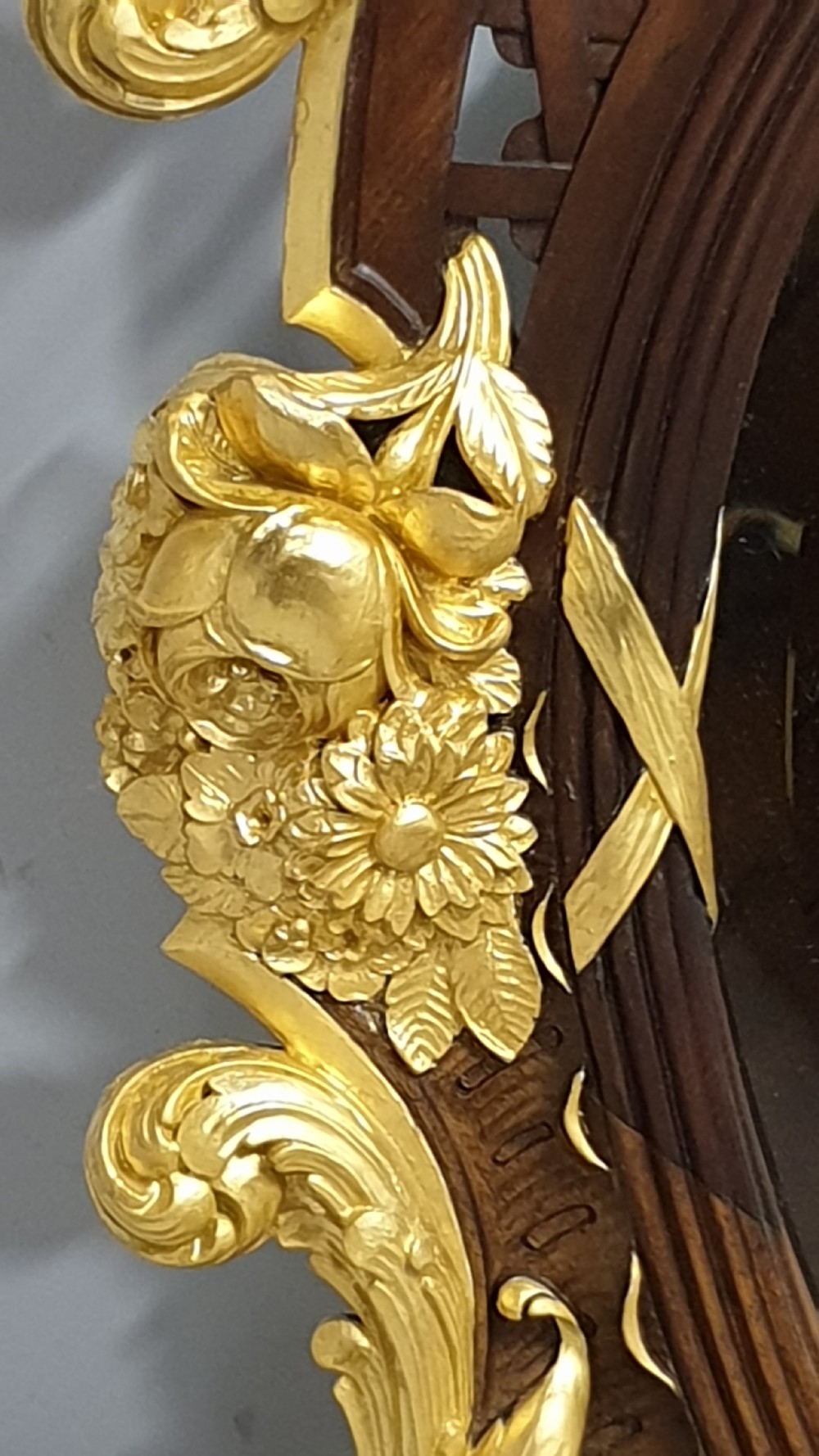 An ornate oval mahogany wall mirror featuring a carved eagle crest, parcel gilt acanthus leaf borders, side lattice panels, and a central classical mask motif at the base. View IV