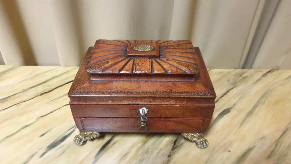 A Regency period tooled brown leather sewing box featuring a sarcophagus-shaped lid, cast brass claw feet, side ring handles, and a lower drawer. View III