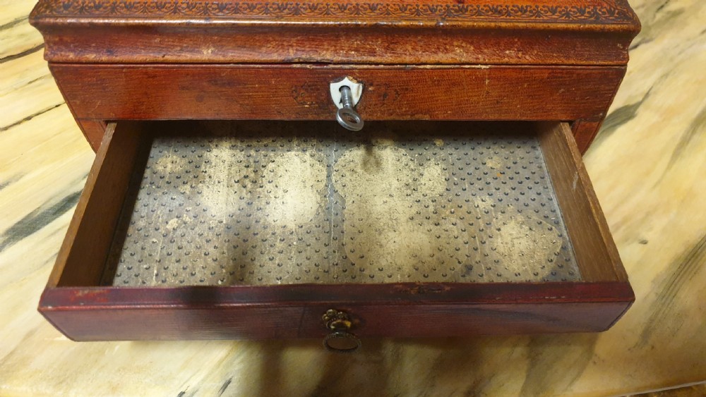 A Regency period tooled brown leather sewing box featuring a sarcophagus-shaped lid, cast brass claw feet, side ring handles, and a lower drawer. View VIII