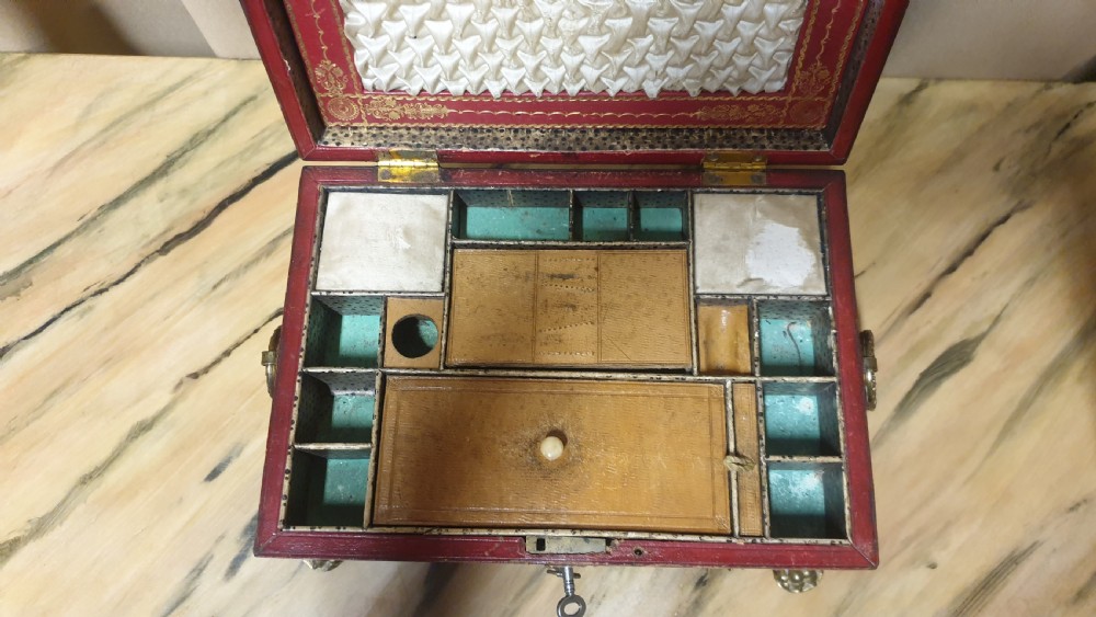 A Regency period tooled brown leather sewing box featuring a sarcophagus-shaped lid, cast brass claw feet, side ring handles, and a lower drawer. View XIII