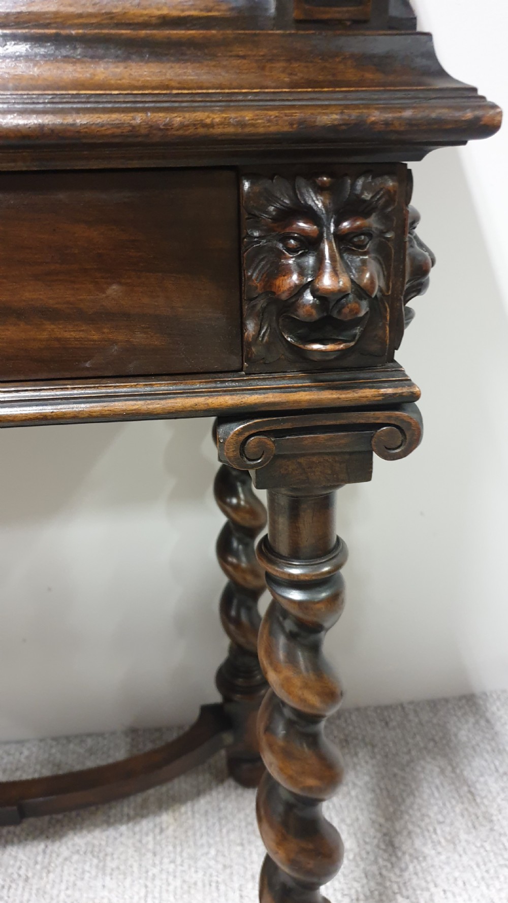 A dark carved walnut cabinet on a stand featuring mother of pearl inlay, carved lion mask details, geometric door panels, and barley twist legs with a stretcher. View VIII