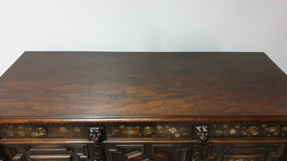 A dark carved walnut cabinet on a stand featuring mother of pearl inlay, carved lion mask details, geometric door panels, and barley twist legs with a stretcher. View XIII