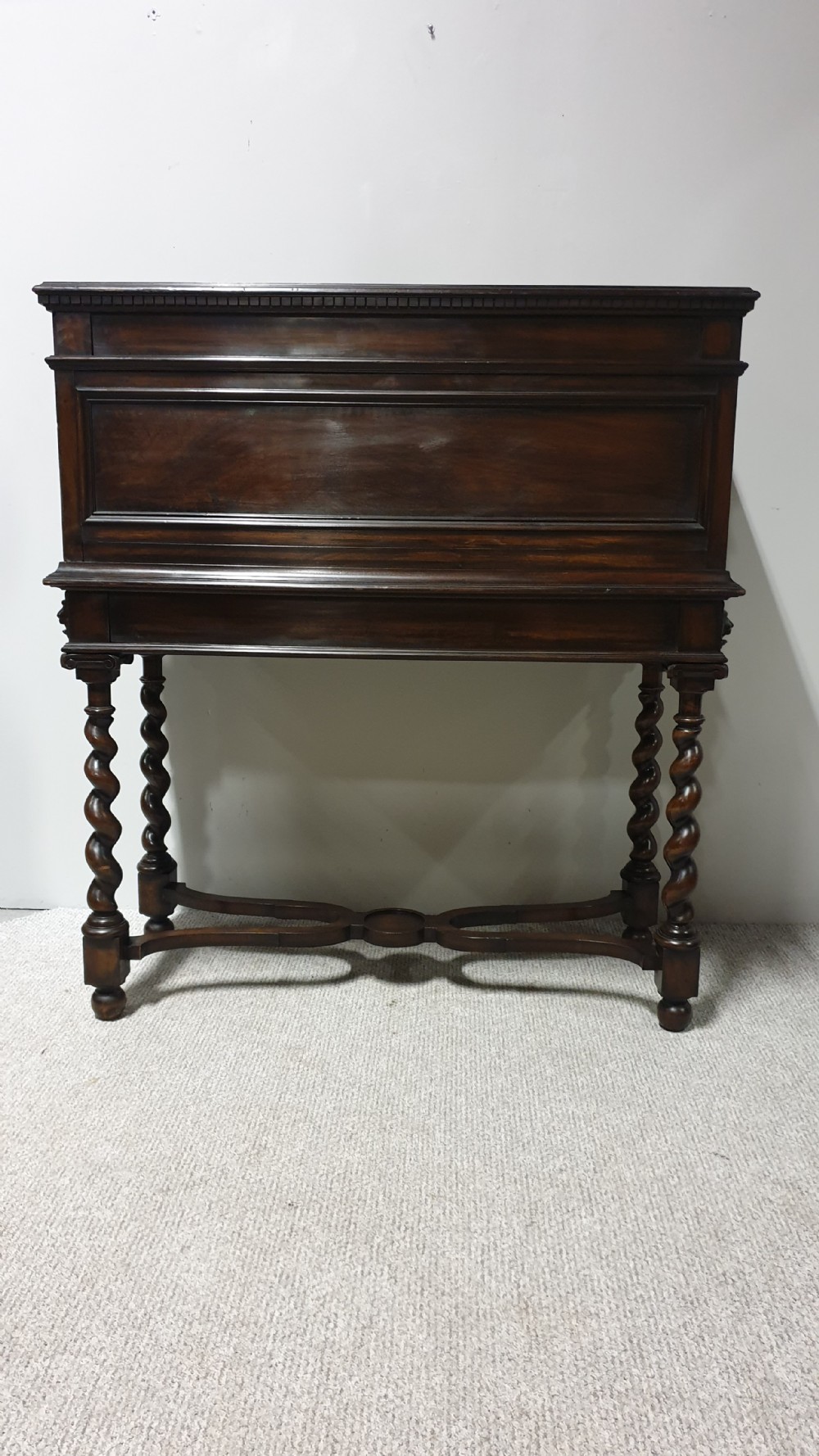 A dark carved walnut cabinet on a stand featuring mother of pearl inlay, carved lion mask details, geometric door panels, and barley twist legs with a stretcher. View XVII