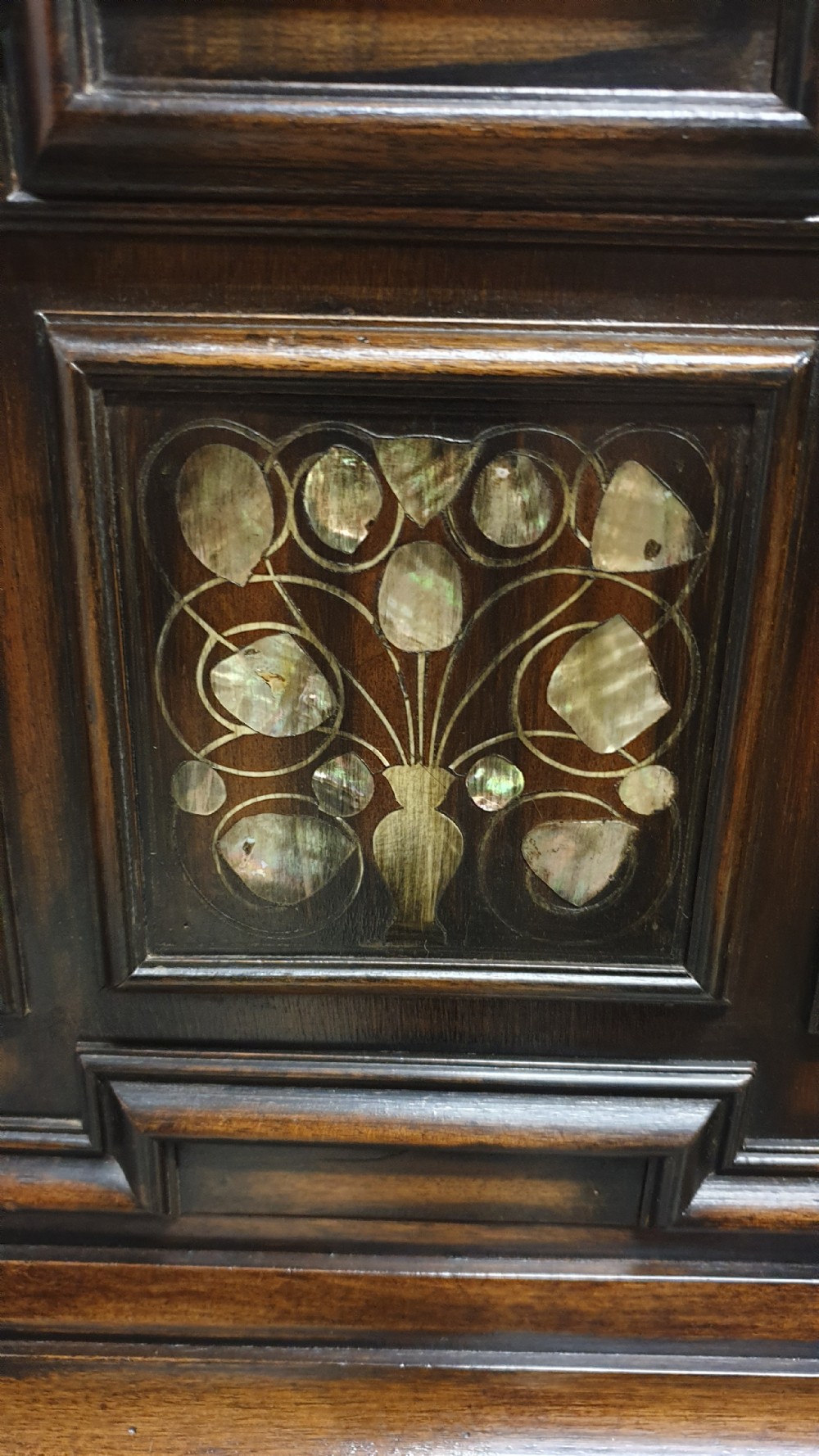 A dark carved walnut cabinet on a stand featuring mother of pearl inlay, carved lion mask details, geometric door panels, and barley twist legs with a stretcher. View XVIII