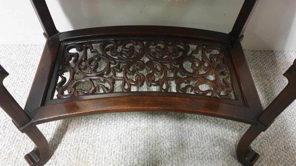 A dark brown Japanese lacquered work table featuring carved dragon head knees, a pierced apron, and a lower openwork shelf. View II