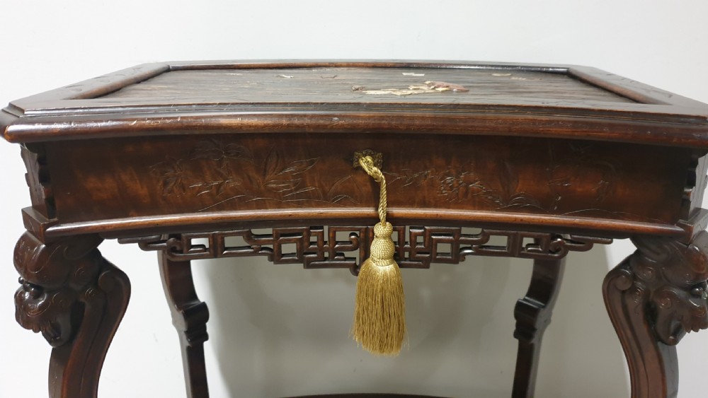 A dark brown Japanese lacquered work table featuring carved dragon head knees, a pierced apron, and a lower openwork shelf. View VII