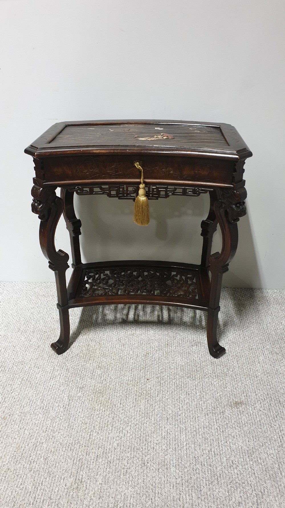 A dark brown Japanese lacquered work table featuring carved dragon head knees, a pierced apron, and a lower openwork shelf. View X