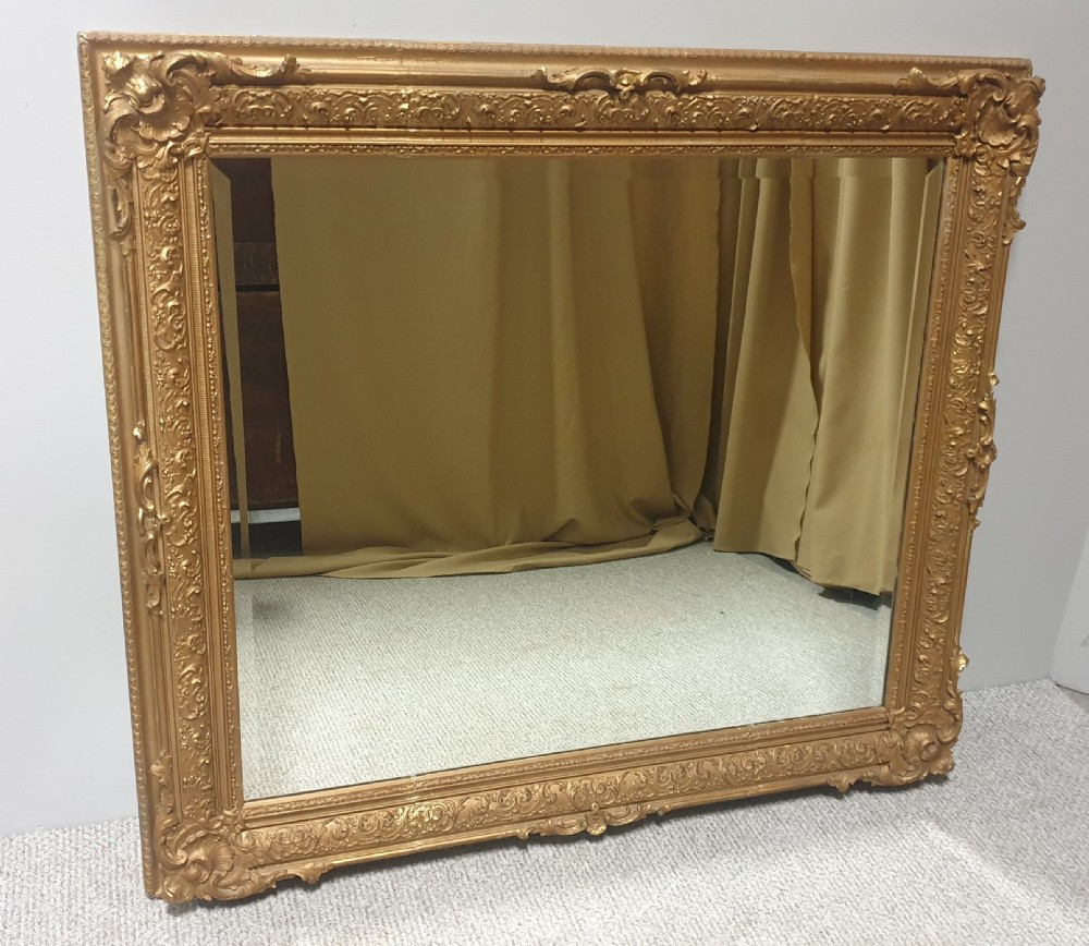 A large rectangular Victorian gilt wall mirror featuring an ornate frame embellished with acanthus leaf and scrollwork mouldings. View IX