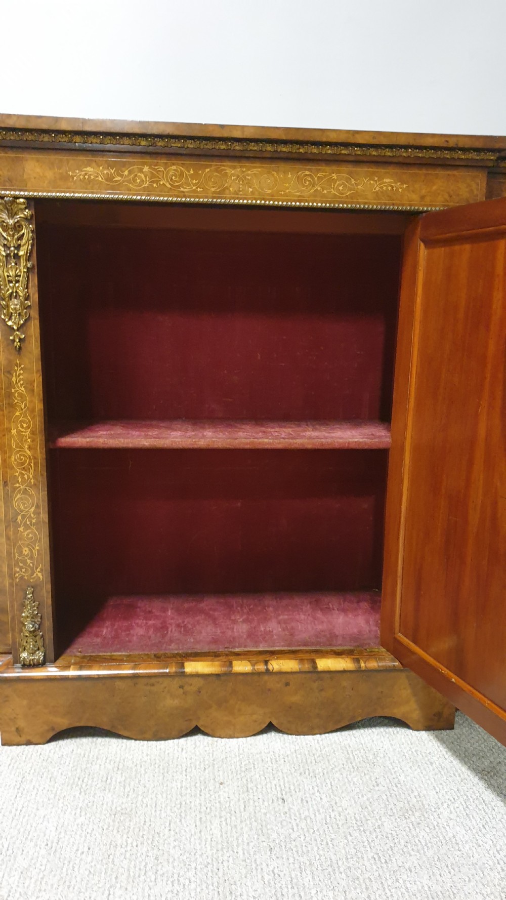 A Victorian burr walnut credenza featuring a central inlaid cupboard door flanked by two curved glazed display side cabinets and decorative gilt ormolu mounts. View IX