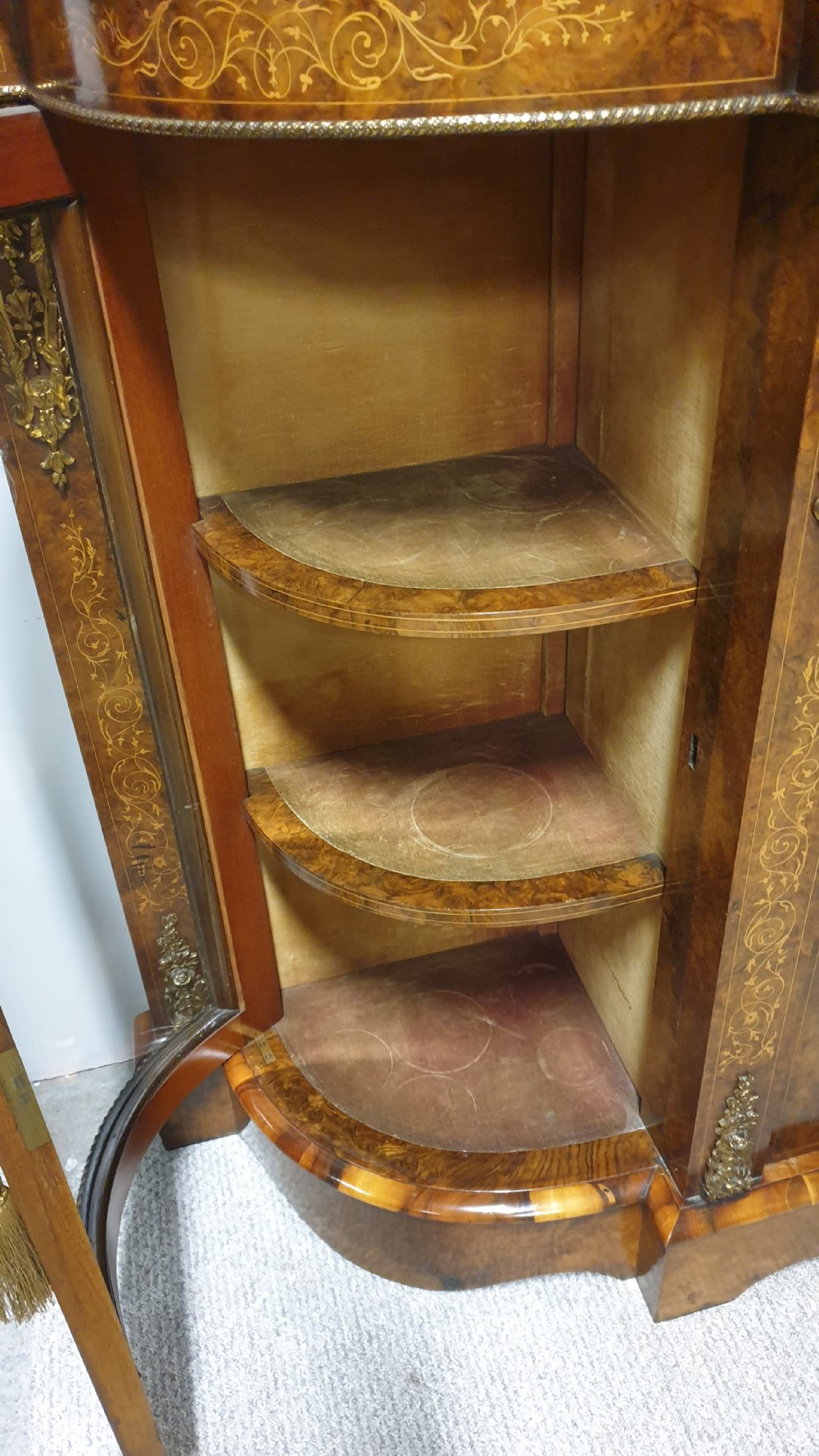 A Victorian burr walnut credenza featuring a central inlaid cupboard door flanked by two curved glazed display side cabinets and decorative gilt ormolu mounts. View XII