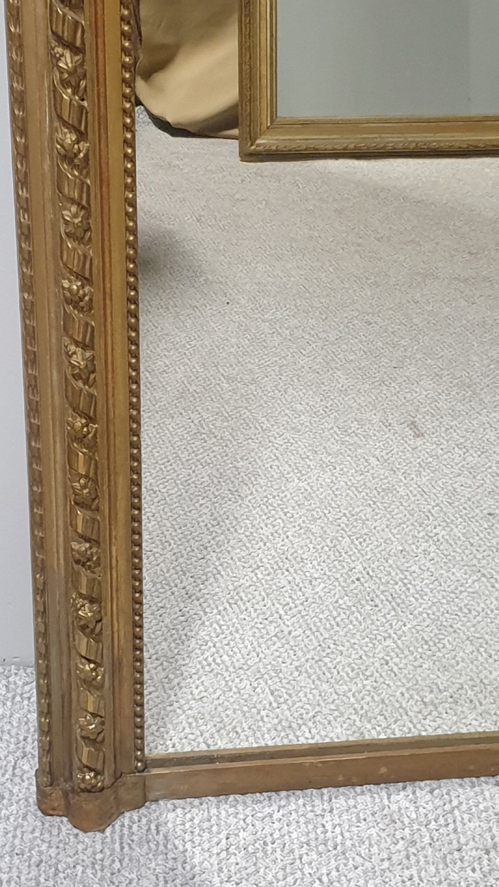 A tall rectangular French giltwood pier mirror topped with an ornate carved crest featuring a musical lyre and foliage. View IV