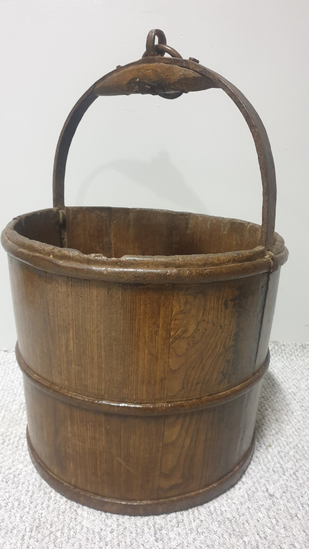 A staved dark oak cylindrical bucket bound with iron hoops and featuring a central overhead iron handle. View II