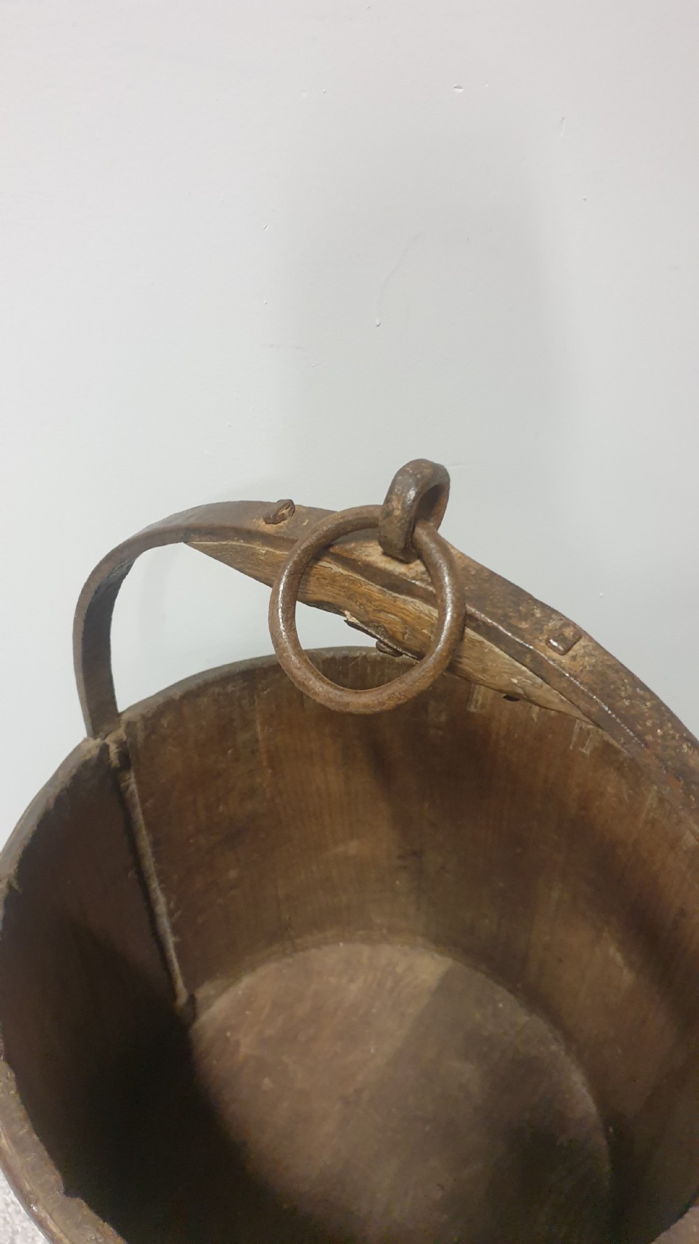 A staved dark oak cylindrical bucket bound with iron hoops and featuring a central overhead iron handle. View III