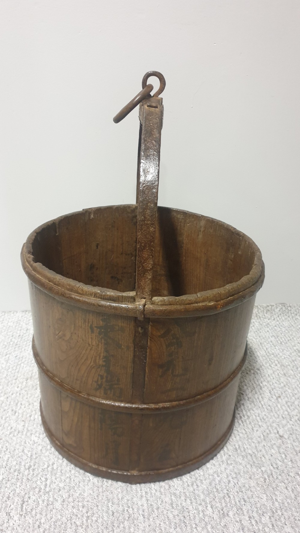 A staved dark oak cylindrical bucket bound with iron hoops and featuring a central overhead iron handle. View IV
