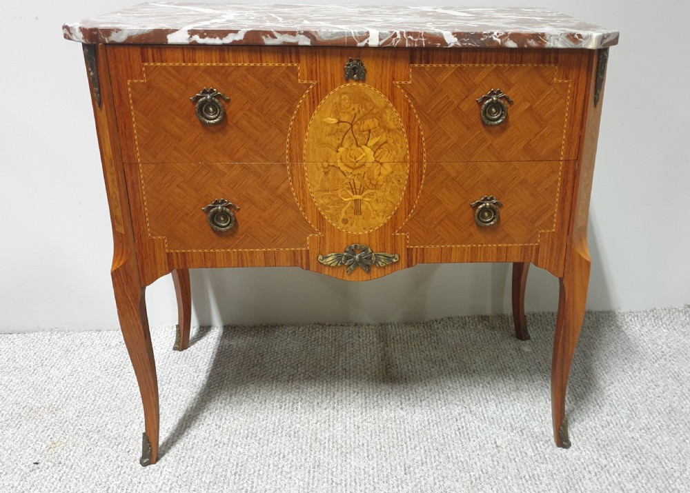 A French-style wooden commode with two drawers, featuring a white and red veined marble top, central floral marquetry medallion, bronze handles, and cabriole legs. View II