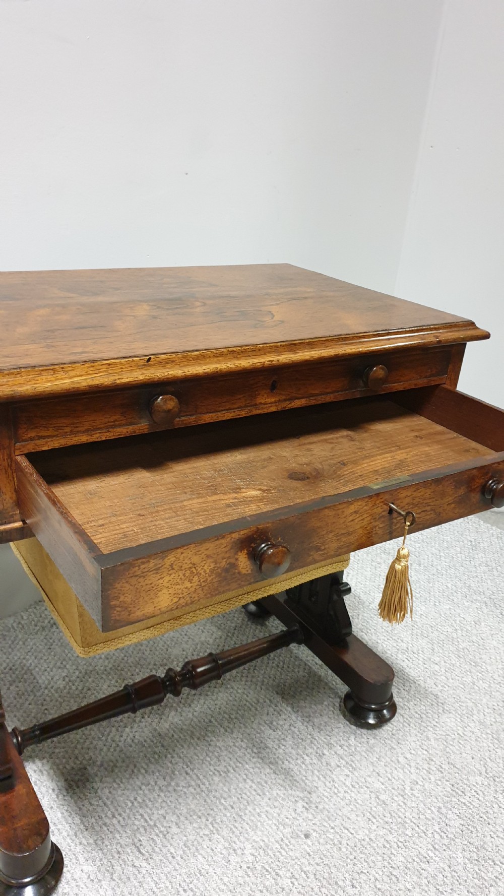 A William IV mahogany sewing table featuring two drawers with turned knobs, a gold fabric well underneath, and trestle supports joined by a turned stretcher. View VIII