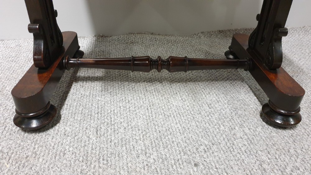 A William IV mahogany sewing table featuring two drawers with turned knobs, a gold fabric well underneath, and trestle supports joined by a turned stretcher. View XIII